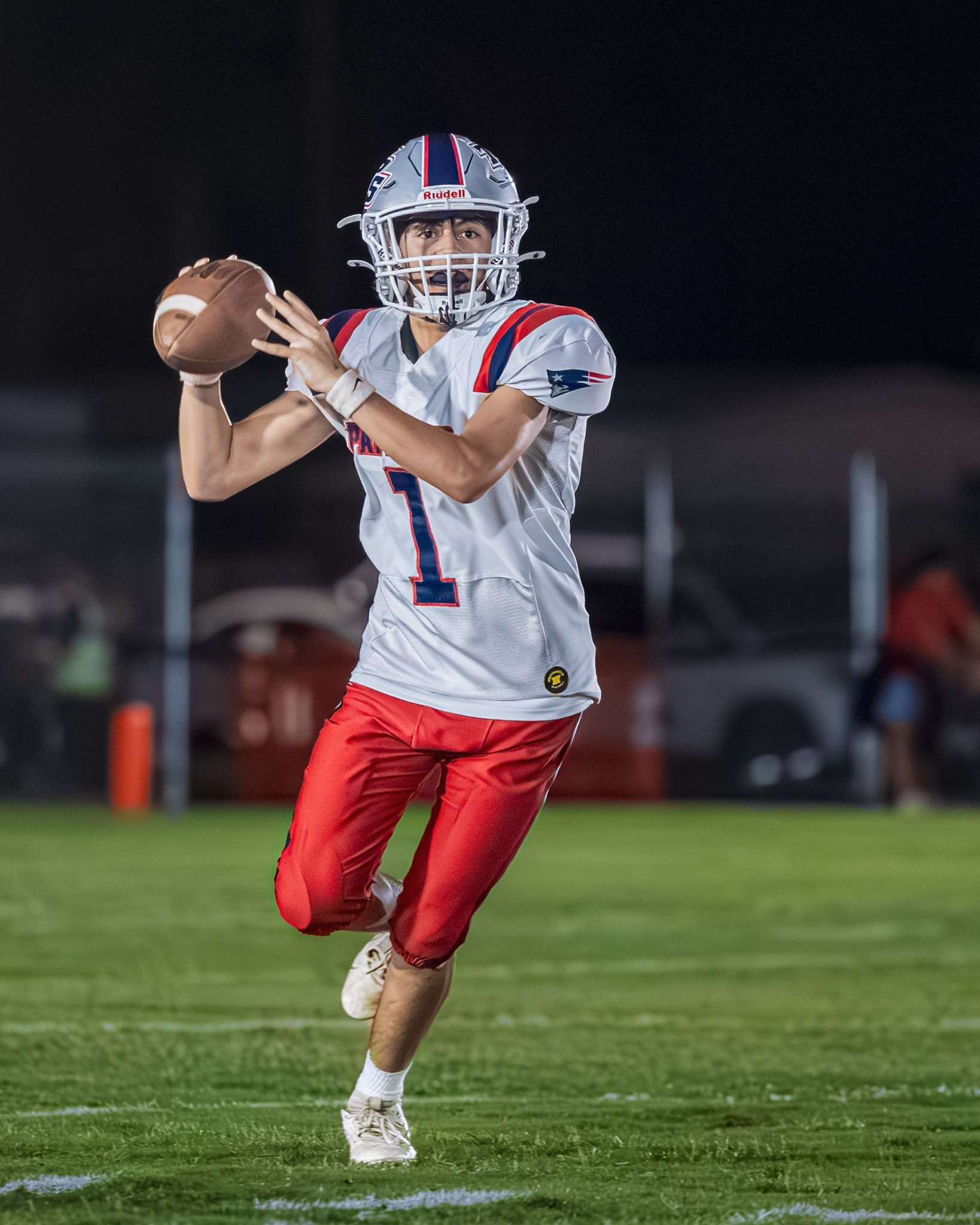 Football player making a leaping catch at night