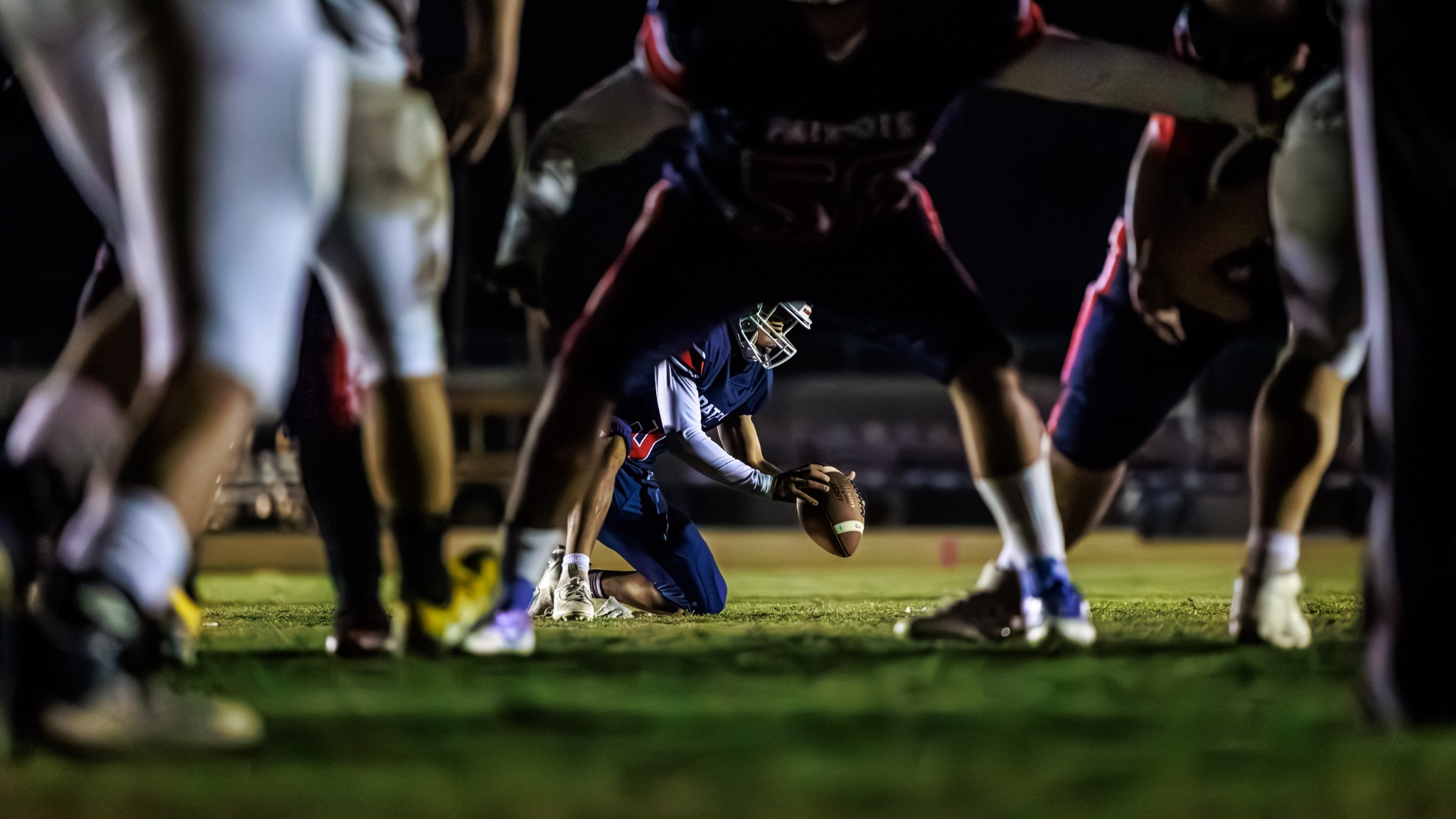 Football player framed through the line of scrimmage